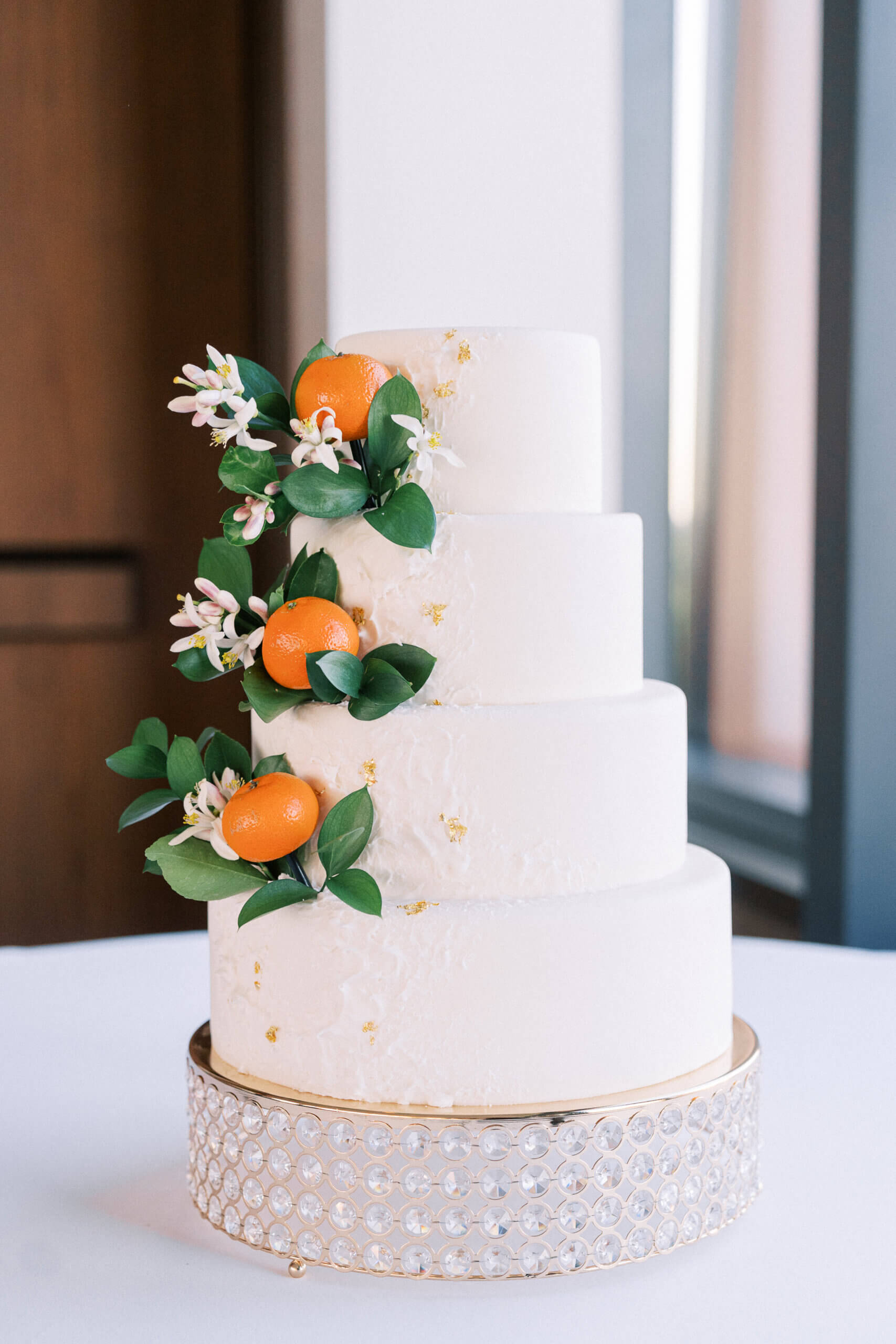 White weddings cake with an orange on each tier.